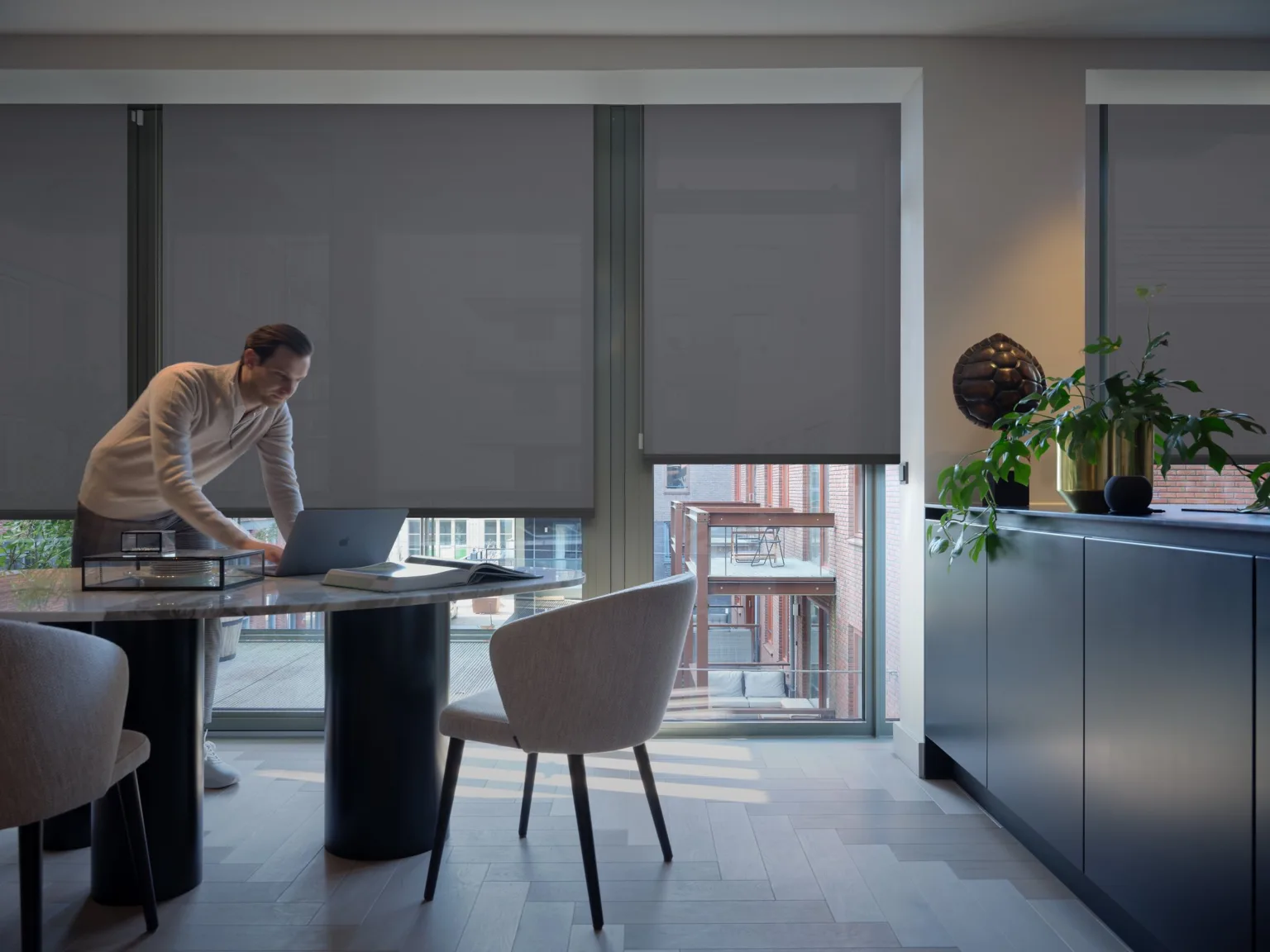 Rulouri electrice Motionblinds într-un living, la lăsarea serii